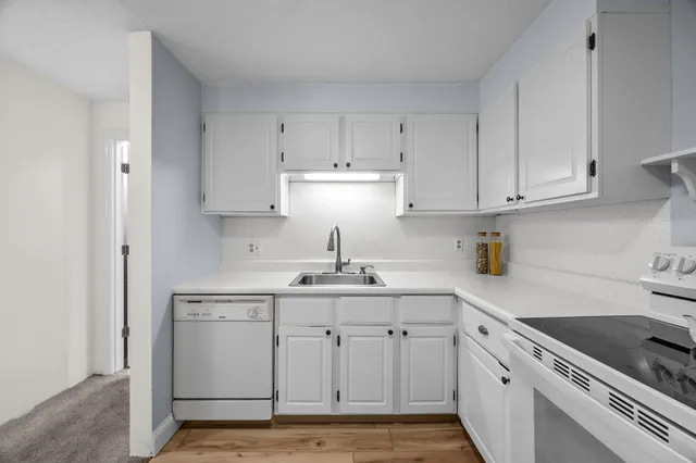 a kitchen with white cabinets stainless steel appliances and sink