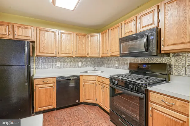 a kitchen with stainless steel appliances granite countertop a stove a sink dishwasher and a refrigerator