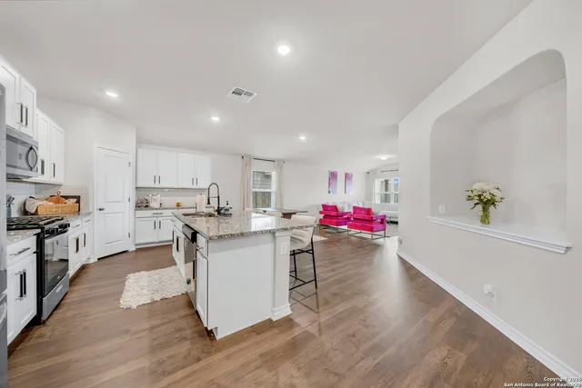 a kitchen view with stainless steel appliances a lot of counter top space and cabinets