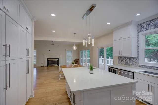 a kitchen with kitchen island granite countertop wooden floors and white stainless steel appliances