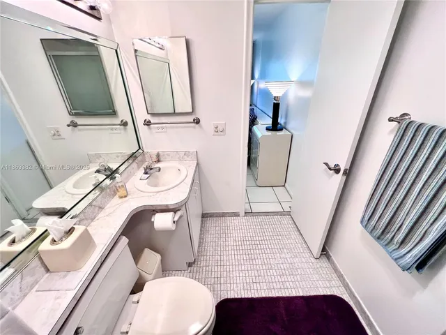 a bathroom with a sink mirror and toilet