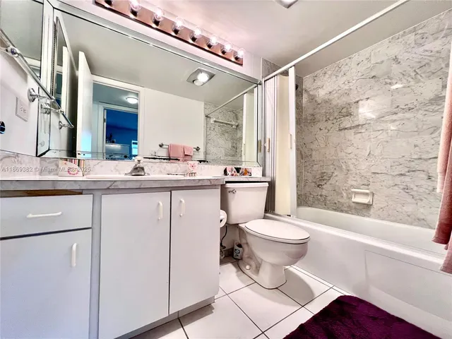 a bathroom with a sink a toilet a mirror and a bathtub