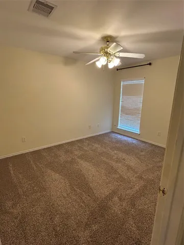 a view of an empty room with a chandelier fan