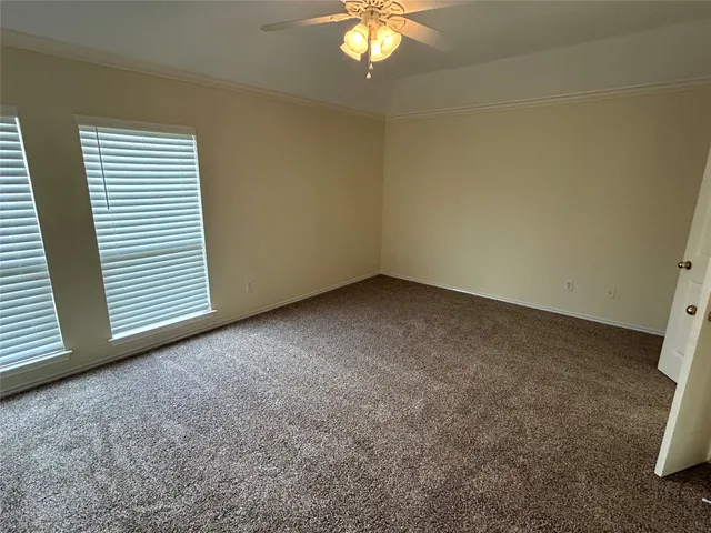 an empty room with a chandelier fan and a window