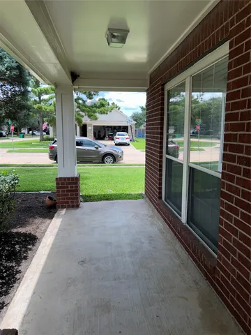 a view of a porch with furniture and garden