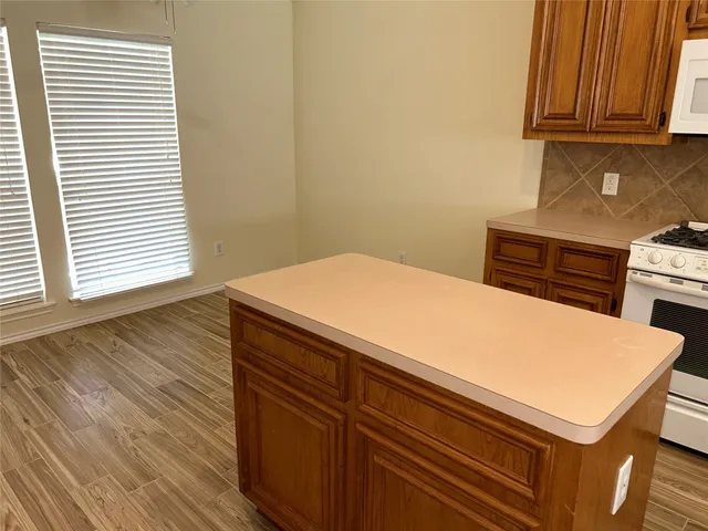 a kitchen with kitchen island a sink cabinets and wooden floor