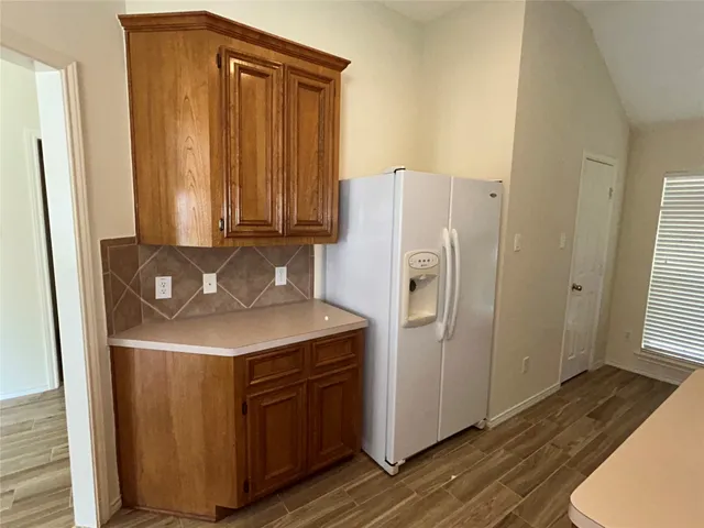 a kitchen with a refrigerator sink and cabinets
