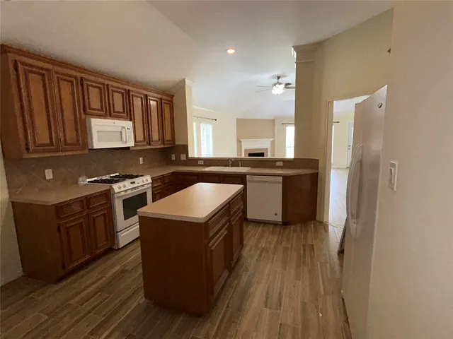 a kitchen with granite countertop a sink stove and refrigerator