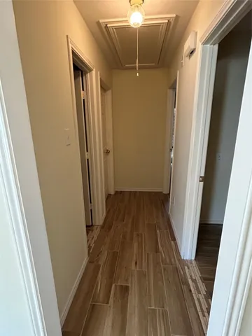 a view of a hallway with wooden floor