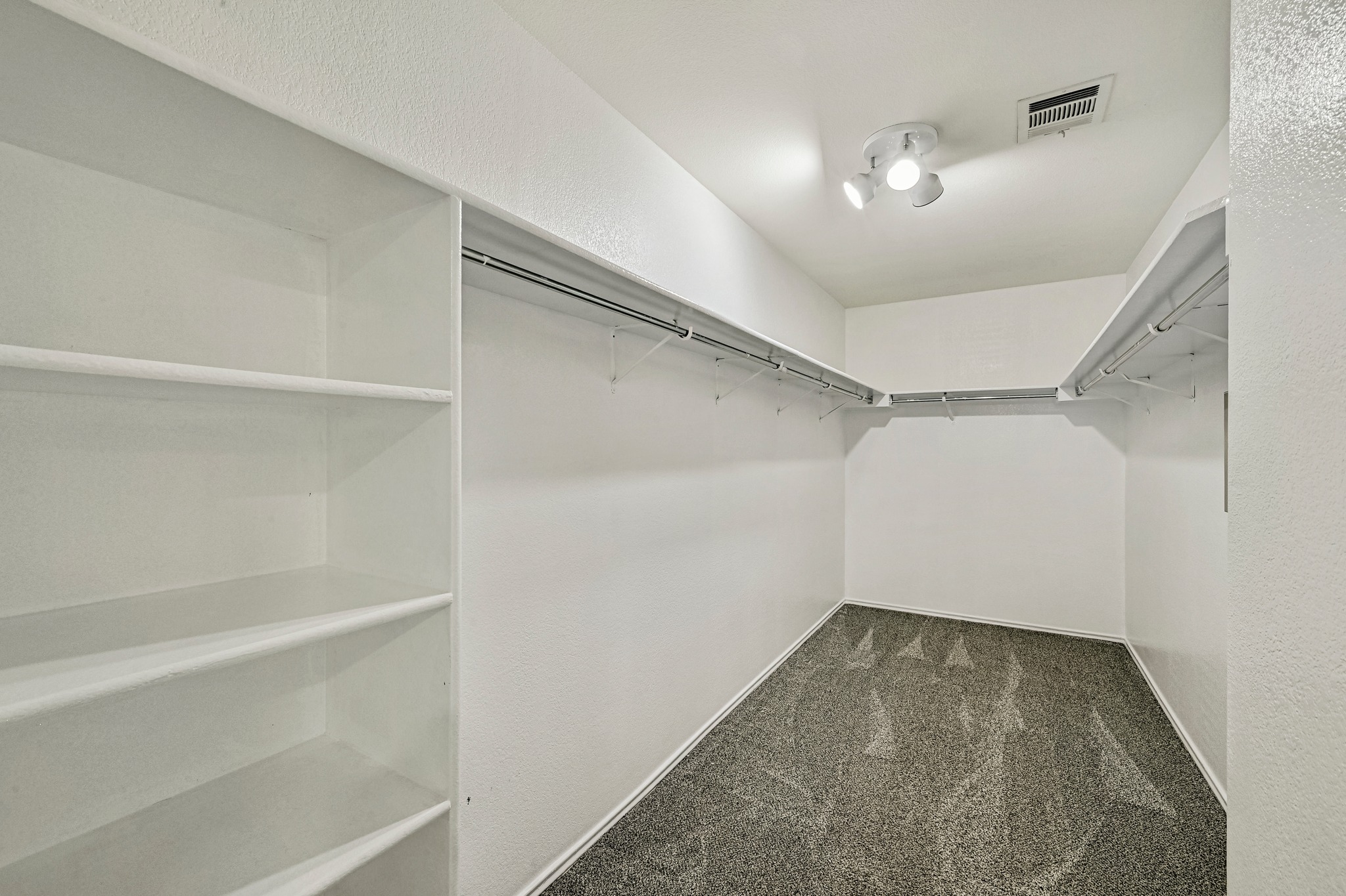 104 North Sumac Lane Georgetown, TX 78633 - Photo 33 of 40 Custom shelving and hanging rods offer ample storage within this practical walk-in closet.