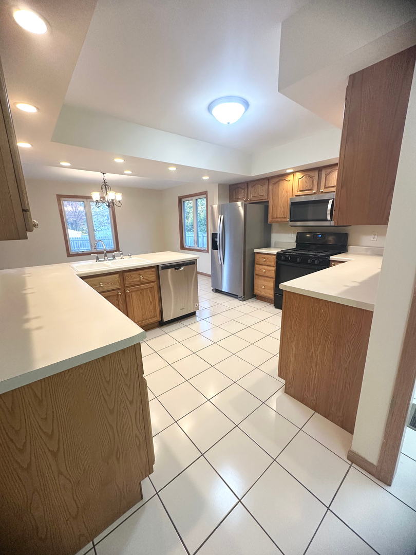 1151 Mary Court DeKalb, IL 60115 - Photo 3 of 20 a large kitchen with a large counter top and refrigerator