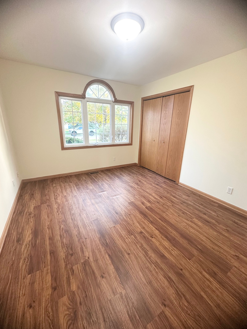1151 Mary Court DeKalb, IL 60115 - Photo 6 of 20 an empty room with wooden floor windows and exposed bricks