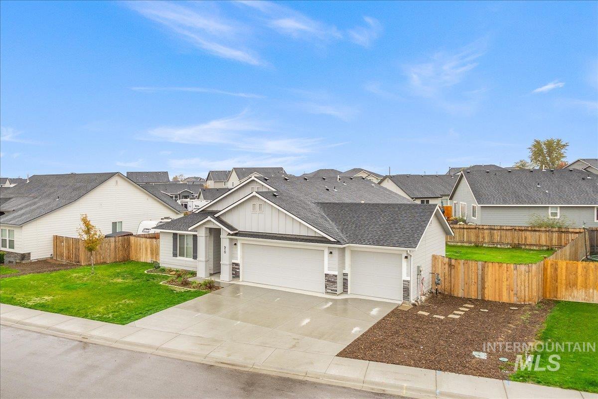 Traditional-style home with a shingled roof, board and batten siding, a garage, driveway, and a residential view