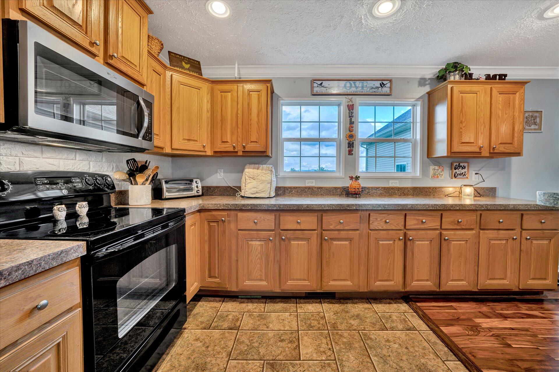 2220 Callaway Road Rocky Mount, VA 24151 - Photo 11 of 22 a kitchen with stainless steel appliances granite countertop a stove a sink and a microwave