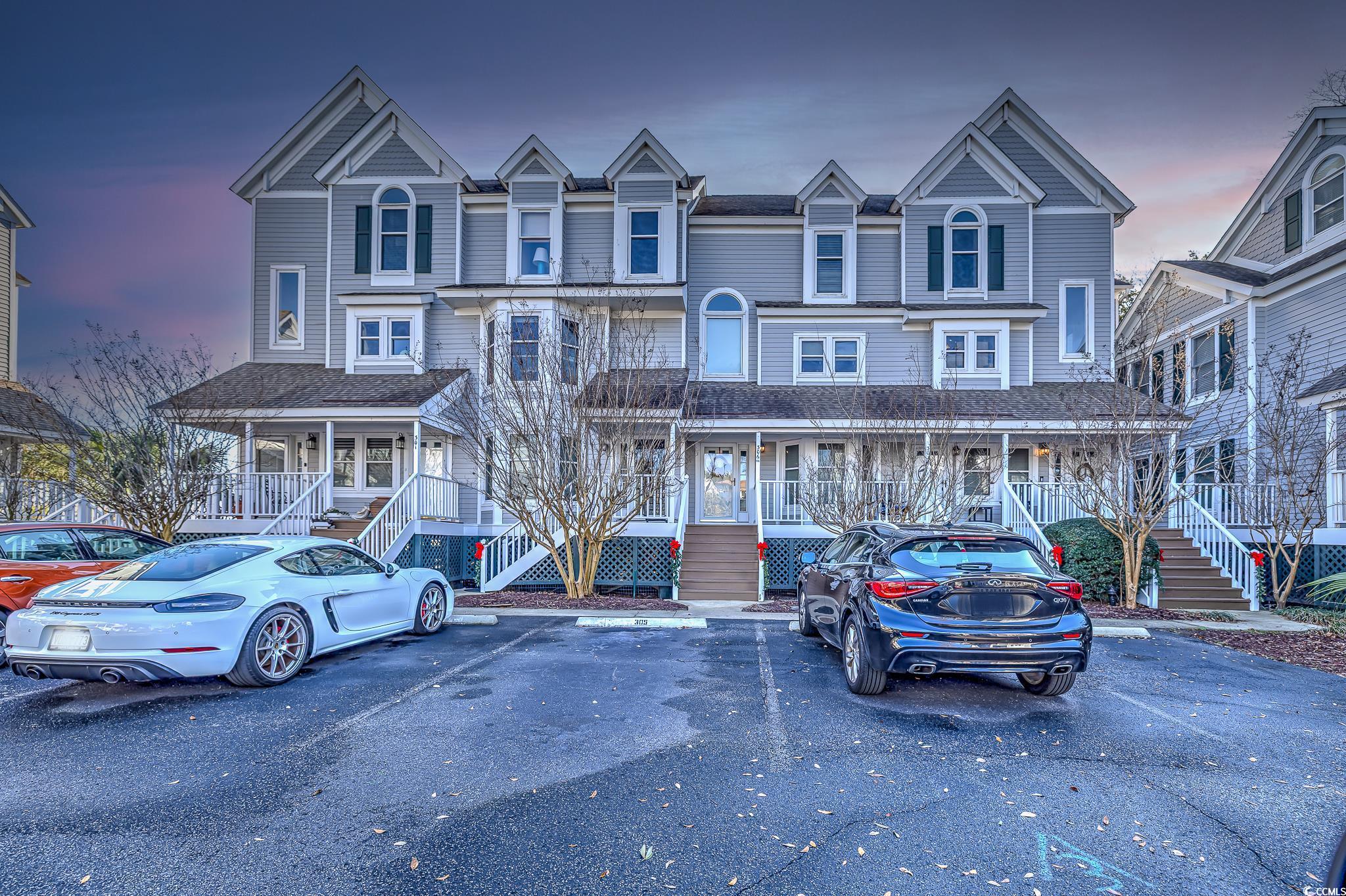 Victorian-style house with uncovered parking, stairway, and a porch