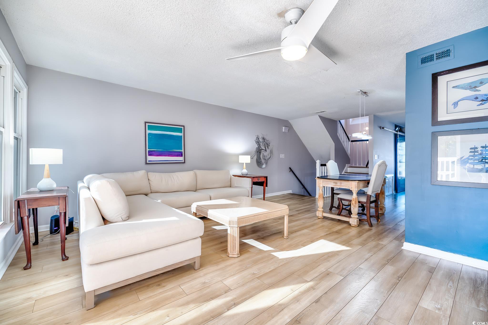 4999 Highway 17 Business, Unit 305 Murrells Inlet, SC 29576 - Photo 18 of 27 Living area with a ceiling fan, light wood-style flooring, and a textured ceiling