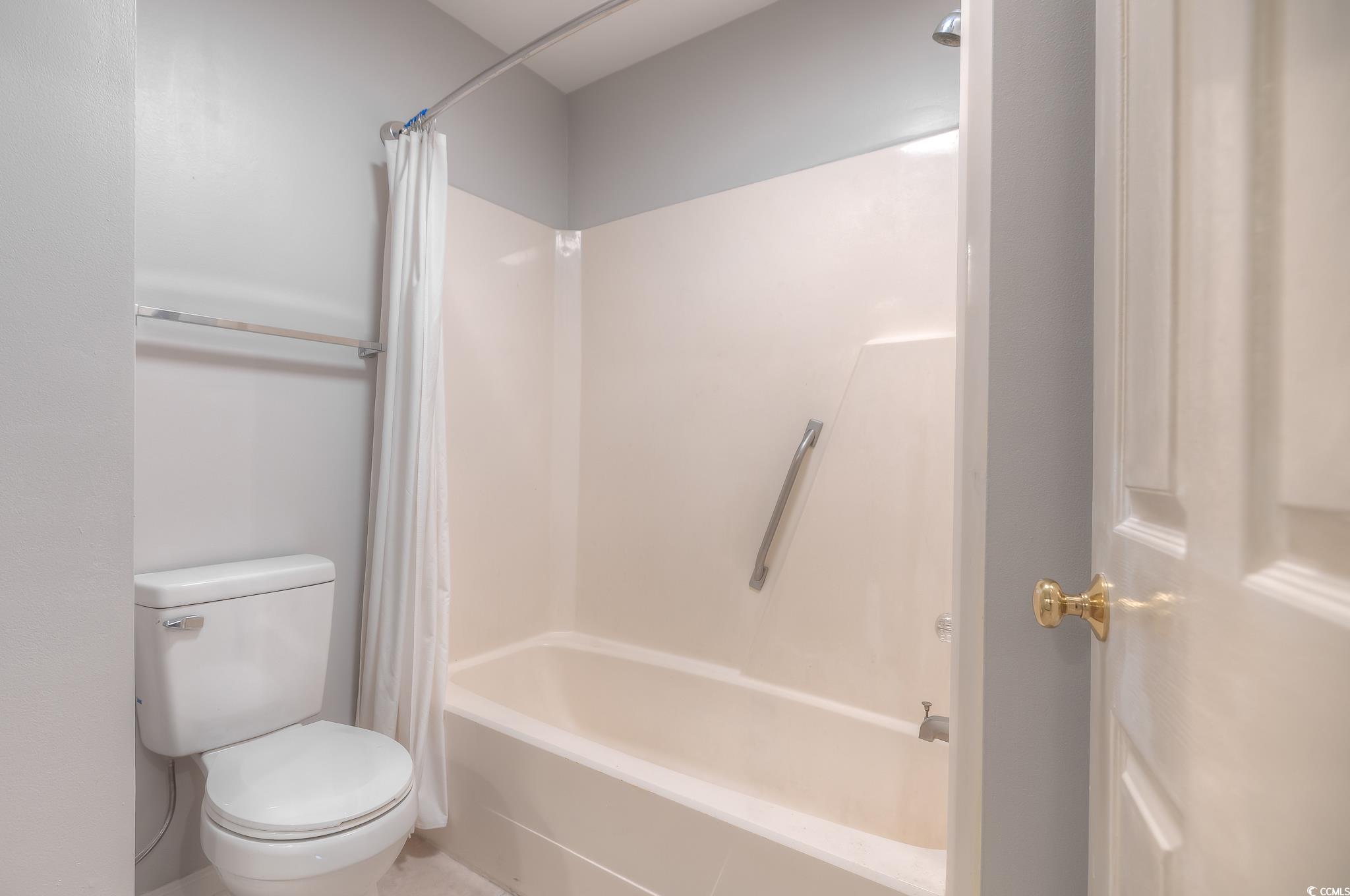 4999 Highway 17 Business, Unit 305 Murrells Inlet, SC 29576 - Photo 23 of 27 Bathroom with toilet and shower / bath combo with shower curtain