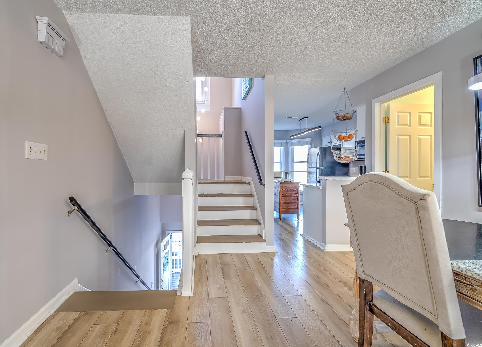4999 Highway 17 Business, Unit 305 Murrells Inlet, SC 29576 - Photo 7 of 27 Staircase featuring wood finished floors and a textured ceiling