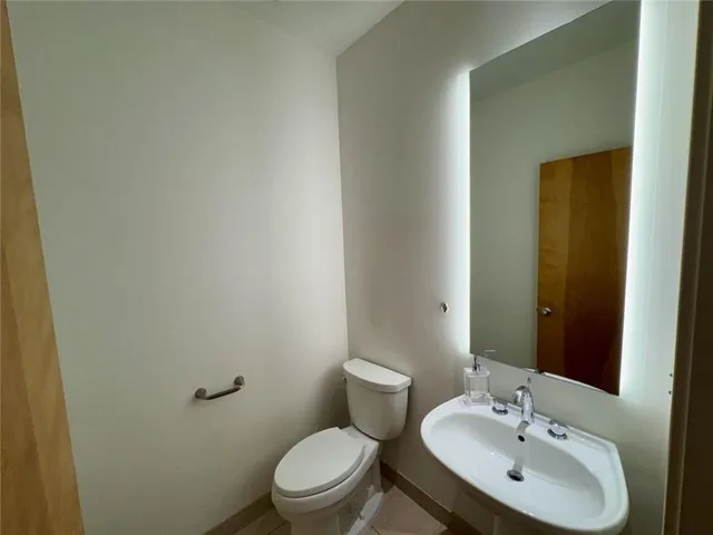 a bathroom with a toilet a sink and mirror