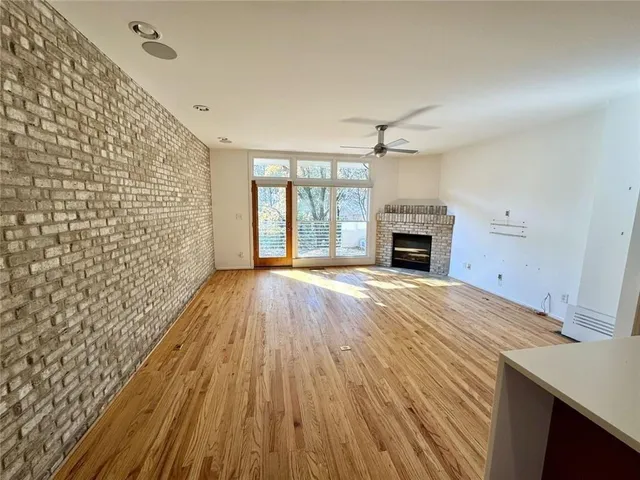 a view of empty room with wooden floor and fireplace