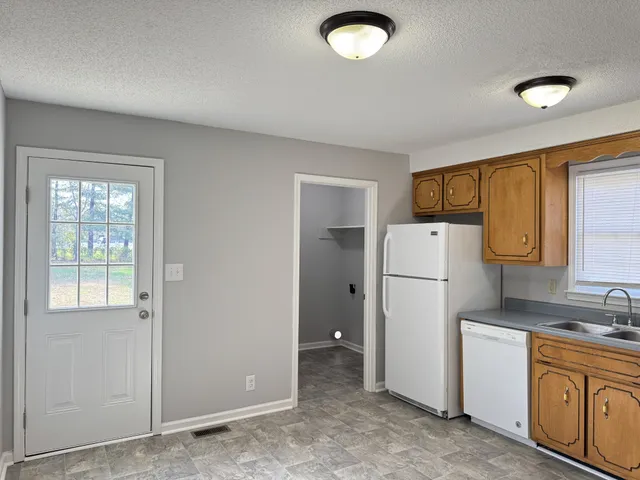 a kitchen with a refrigerator sink stove and cabinets