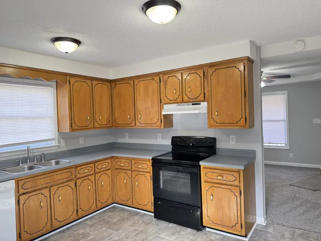 a kitchen with stainless steel appliances granite countertop a sink stove and cabinets