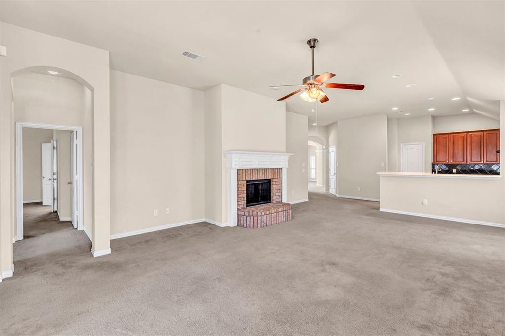 5316 Ridgeson Drive McKinney, TX 75071 - Photo 16 of 33 Spacious interior with an inviting brick fireplace, white mantel, and ceiling fan