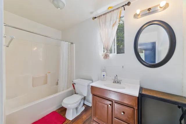 a bedroom with a bed couch and windows