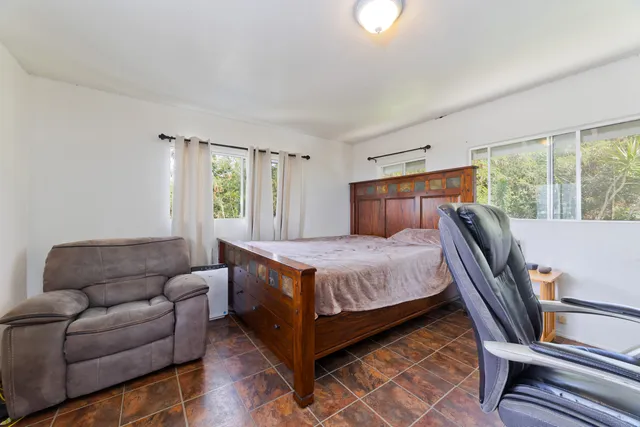 a bedroom with a bed window and chair