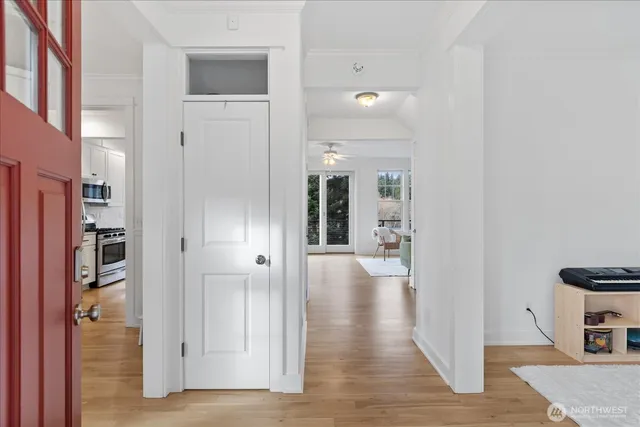 a view of a hallway with wooden floor and living room