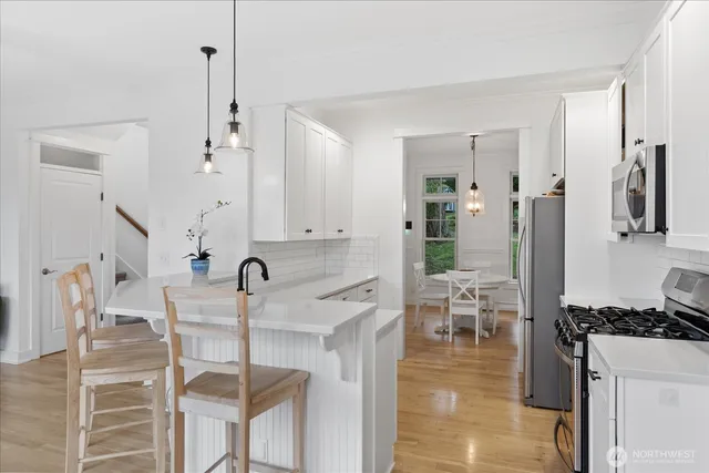 a kitchen with stainless steel appliances kitchen island granite countertop a table and chairs in it