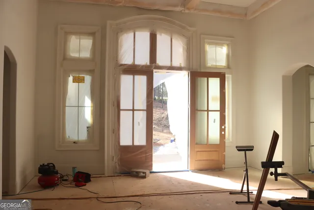 a view of a livingroom with lounge chair and windows