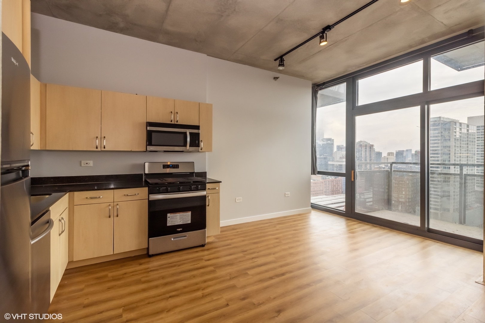235 West Van Buren Street, Unit 2304 Chicago, IL 60607 - Photo 2 of 13 a kitchen with stainless steel appliances granite countertop a stove a sink and a microwave