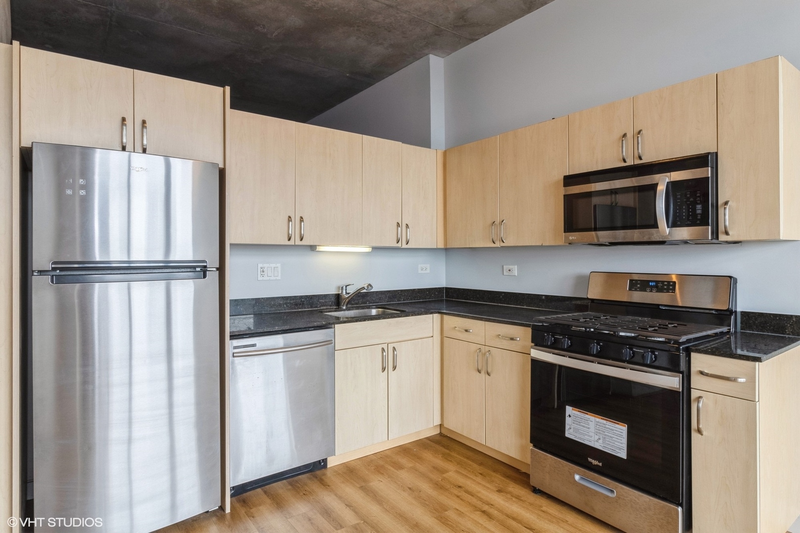 235 West Van Buren Street, Unit 2304 Chicago, IL 60607 - Photo 3 of 13 a kitchen with granite countertop white cabinets and stainless steel appliances