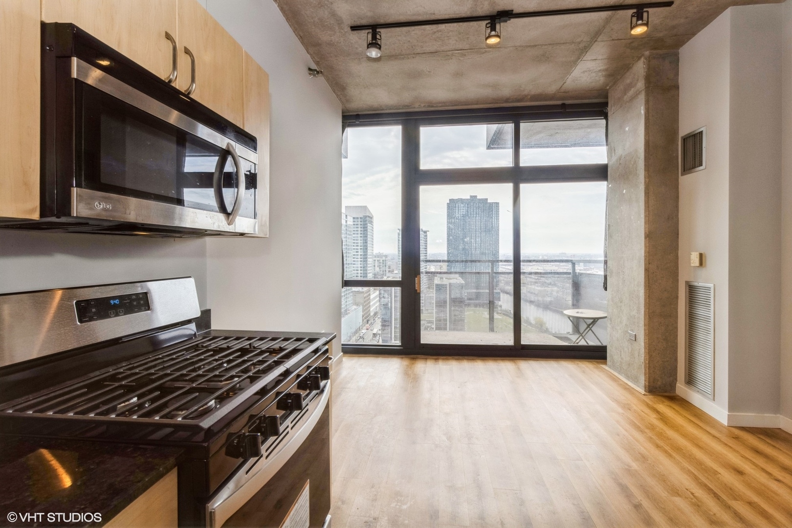 235 West Van Buren Street, Unit 2304 Chicago, IL 60607 - Photo 5 of 13 a kitchen with wooden floor a sink and a stove top oven