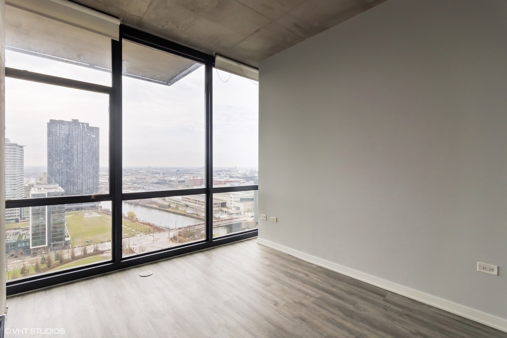 235 West Van Buren Street, Unit 2304 Chicago, IL 60607 - Photo 6 of 13 an empty room with wooden floor and windows