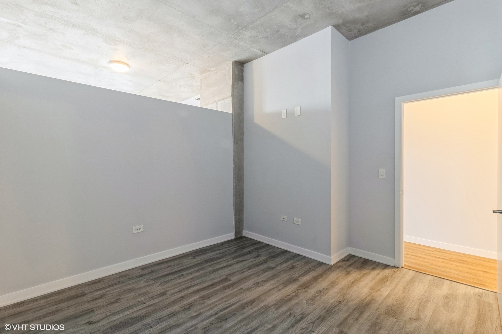 235 West Van Buren Street, Unit 2304 Chicago, IL 60607 - Photo 10 of 13 a view of an empty room with wooden floor and a window