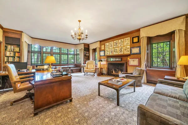 a living room with furniture a fireplace and a chandelier
