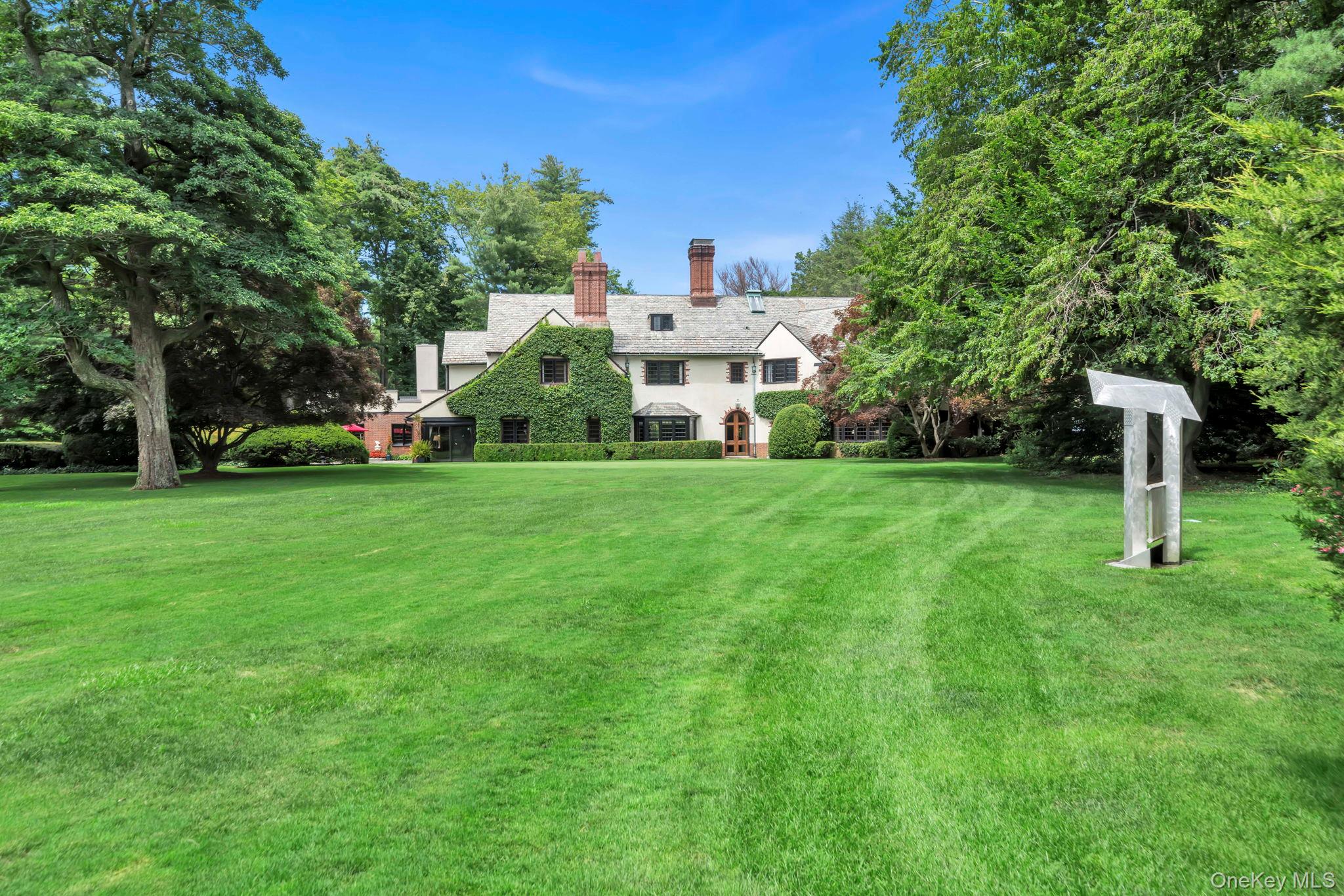 95 Piping Rock Road Locust Valley, NY 11560 - Photo 32 of 39 a view of a house with a yard and sitting area
