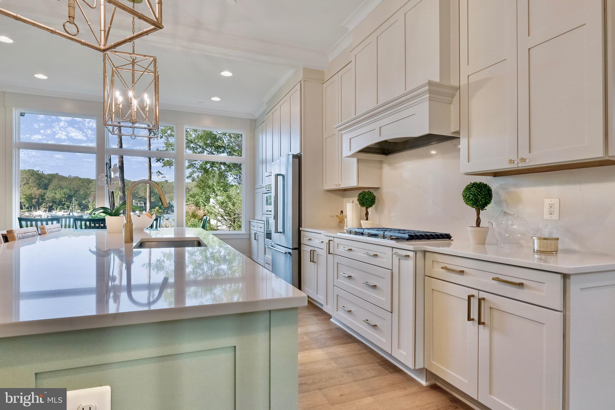 946 Benning Road Galesville, MD 20765 - Photo 8 of 57 a kitchen with stainless steel appliances granite countertop a stove a sink and white cabinets with wooden floor