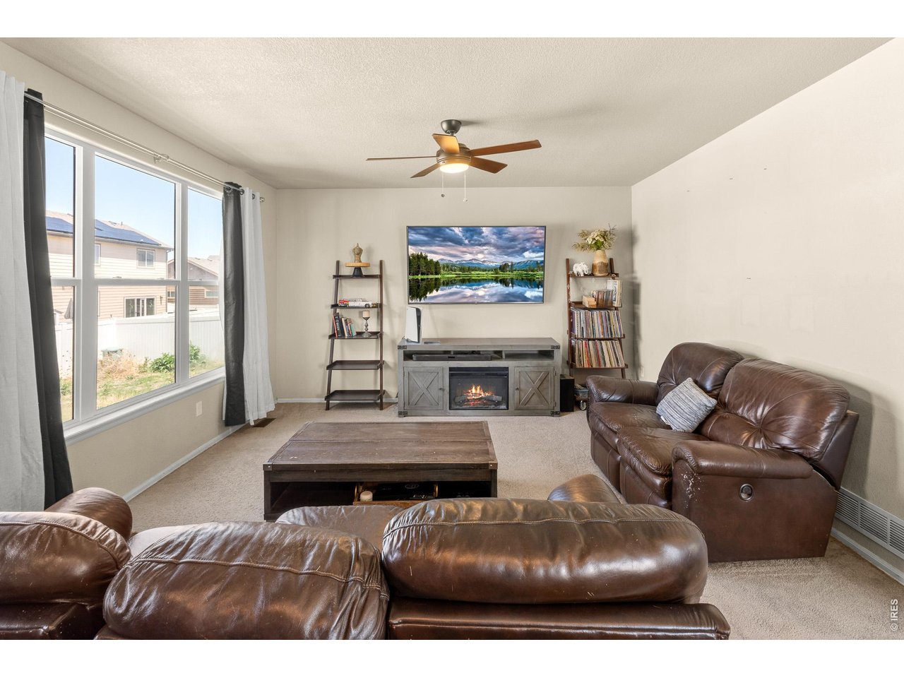 8847 16th St Road Greeley, CO 80634 - Photo 8 of 38 a living room with furniture a fireplace and a flat screen tv