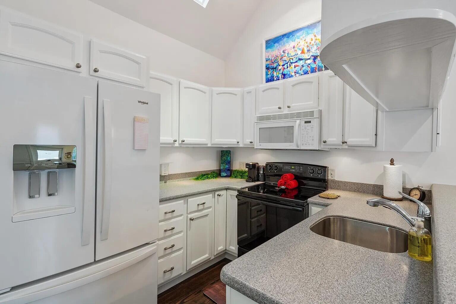 817 Terry Lane Key West, FL 33040 - Photo 9 of 20 a kitchen with white cabinets and white appliances