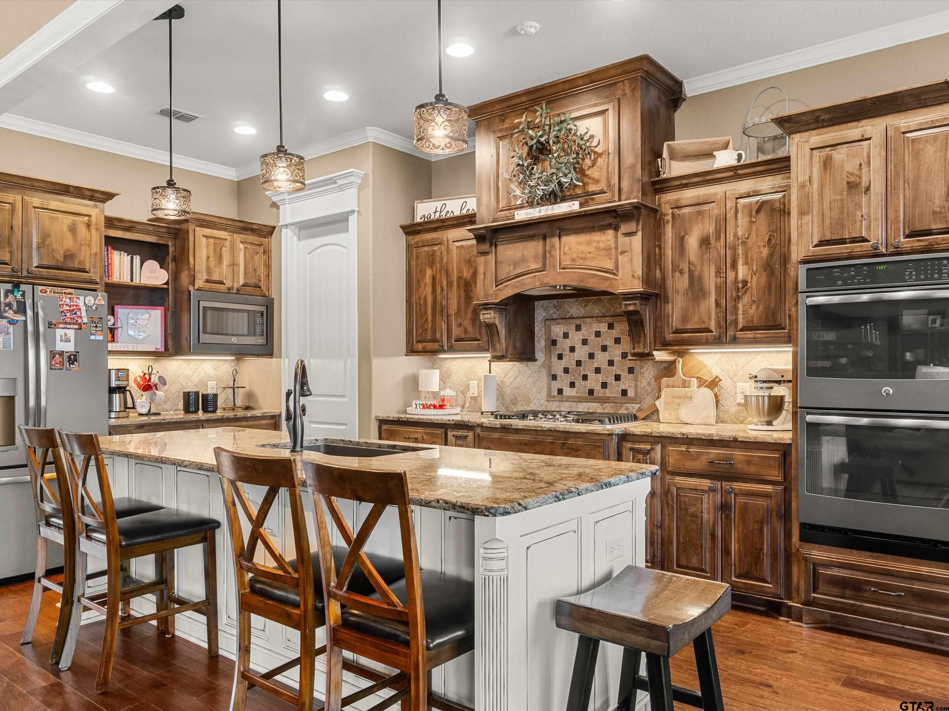 11087 Wolverine Road Pittsburg, TX 75686 - Photo 12 of 39 a kitchen with stainless steel appliances granite countertop a kitchen island a stove a table and chairs in it