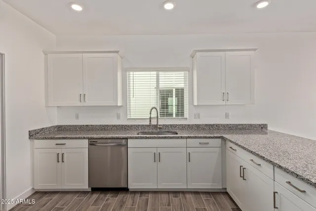 a kitchen with granite countertop white cabinets and a stove