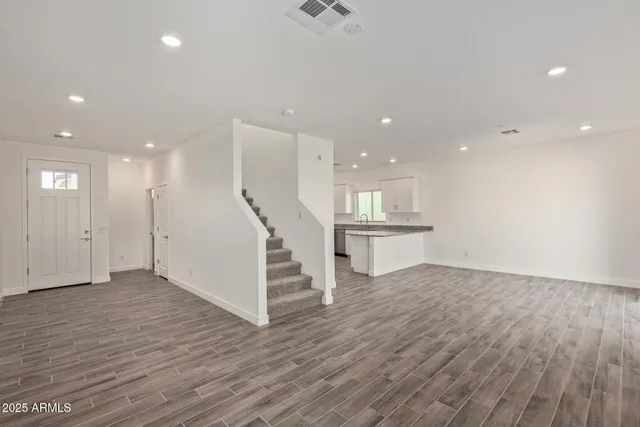 a large kitchen with a wooden floor and white cabinets