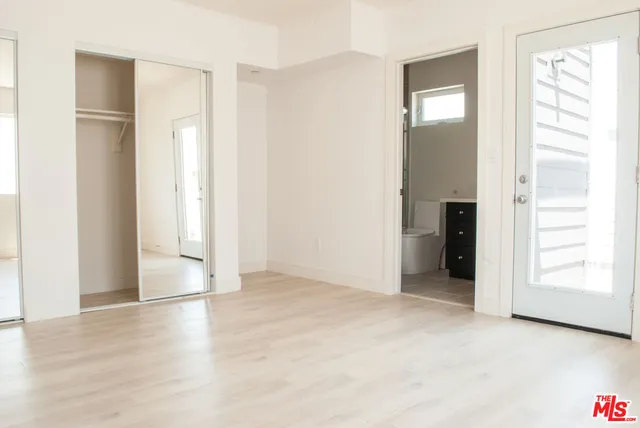 an empty room with closet and a window