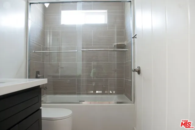 a bathroom with a bathtub shower sink vanity and toilet