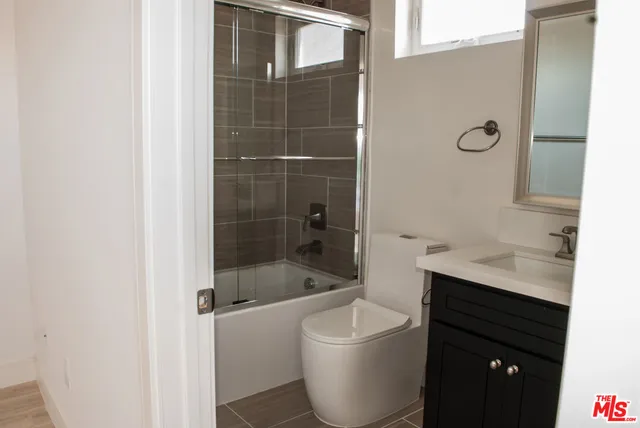 a bathroom with a bathtub shower sink and mirror