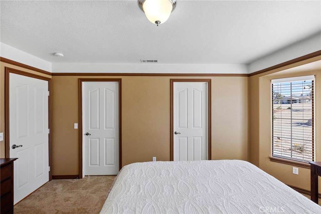 11025 El Esteban Road Phelan, CA 92371 - Photo 30 of 54 a bedroom with a large bed and a window