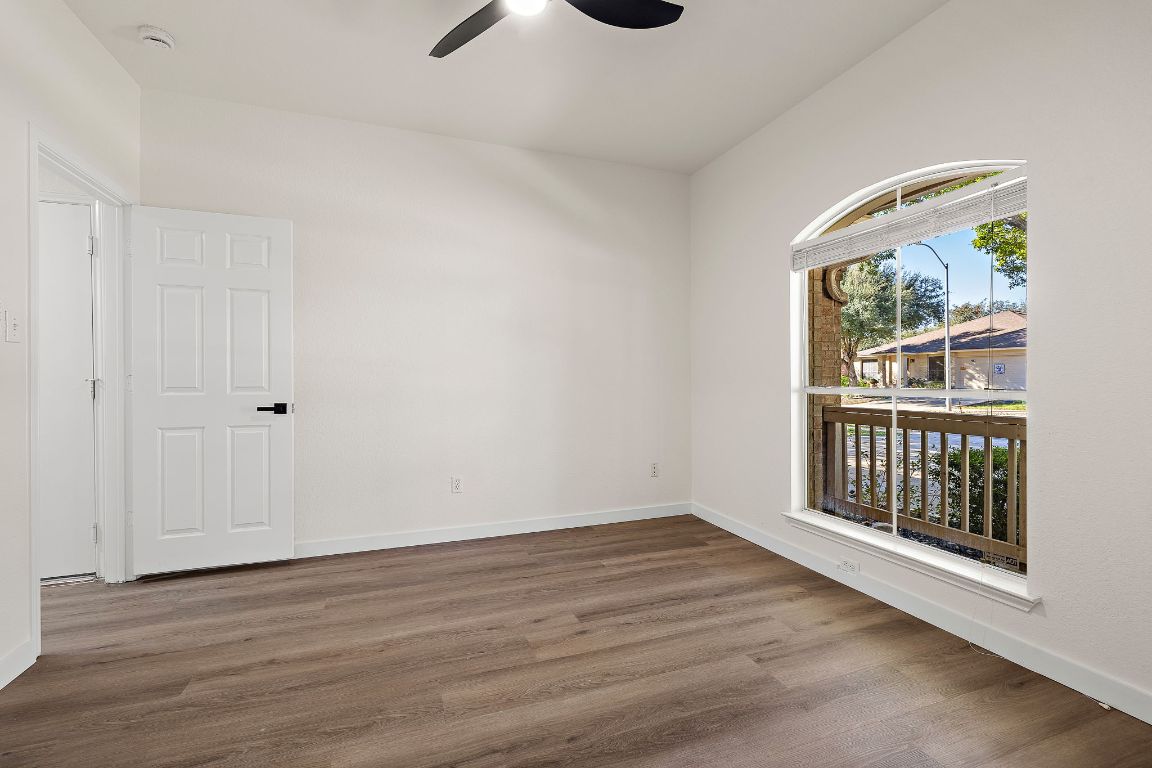 3219 Arroyo Bluff Lane Round Rock, TX 78681 - Photo 15 of 27 a view of an empty room with wooden floor and a window